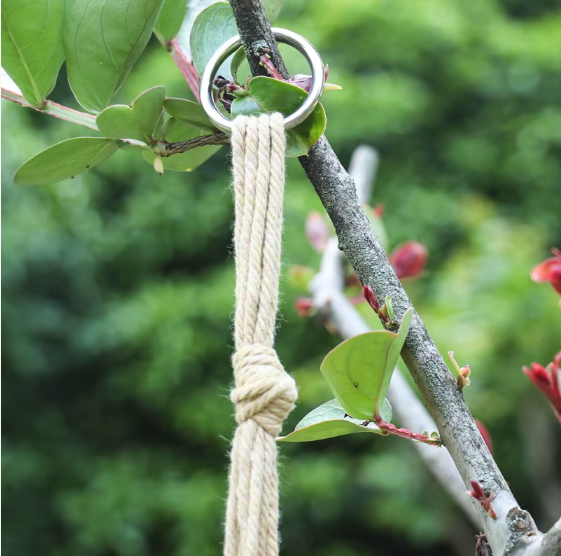 Gros plan d'un anneau métallique au-dessus d'une corde nouée d'un porte-plante suspendu en macramé