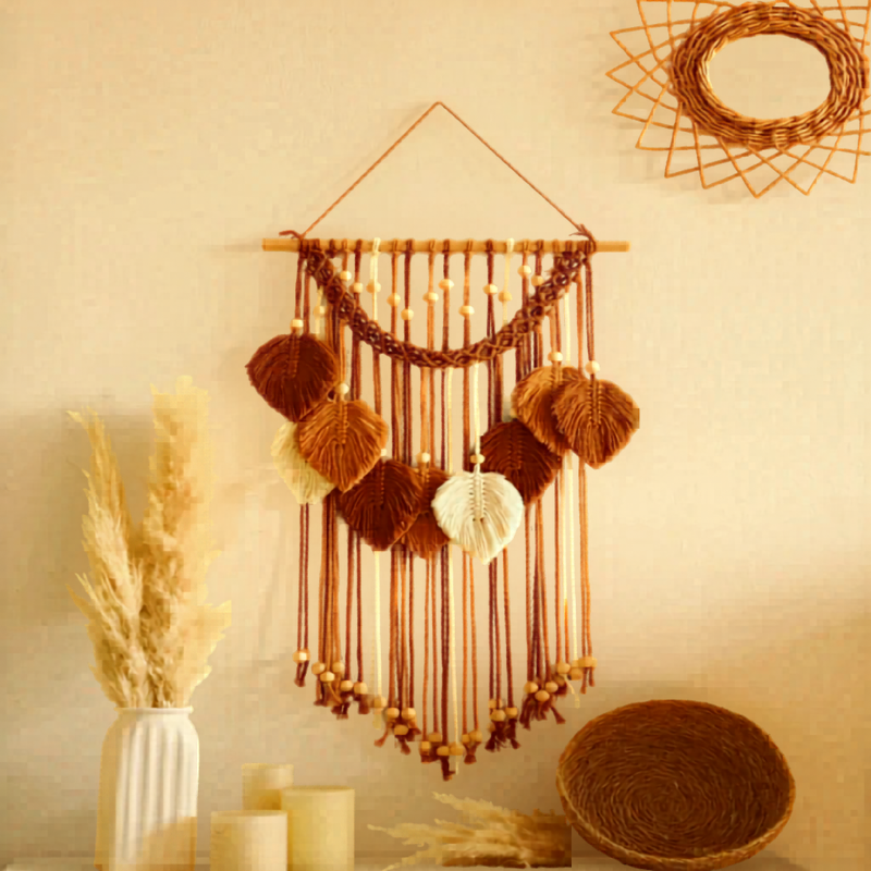 Tenture murale macramé Arcelle terracotta au-dessus d'une table avec un vase et des herbes de la pampa