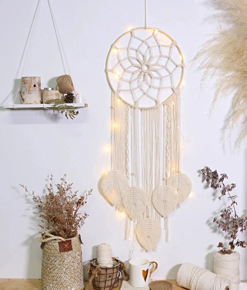 attrape rêve macramé - modèle écru éclairé par une guirlande lumineuse, herbes de la pampa à côté