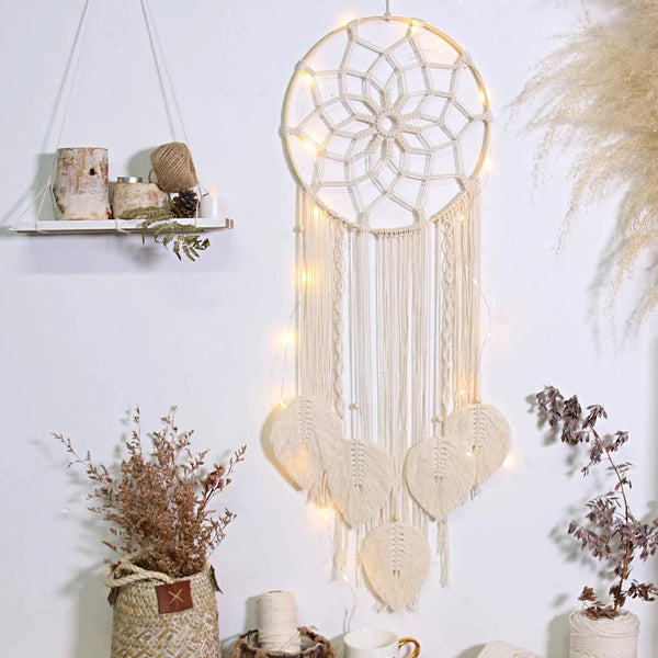 attrape rêve macramé - modèle écru éclairé par une guirlande lumineuse, herbes de la pampa à côté