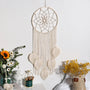 attrape rêve macramé - modèle écru à cinq feuilles sur mur blanc, fleurs séchées en décor