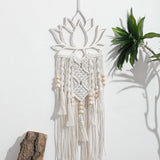 attrape rêve macramé - lotus en bois découpé et franges en corde blanche avec perles de bois, accroché au mur