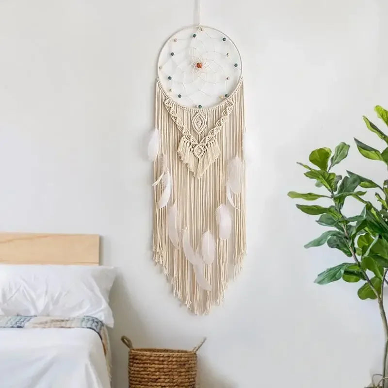 attrape rêve macramé - attrape-rêve en macramé écru et plumes blanches au-dessus d'un lit