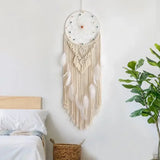 attrape rêve macramé - attrape-rêve en macramé écru et plumes blanches au-dessus d'un lit