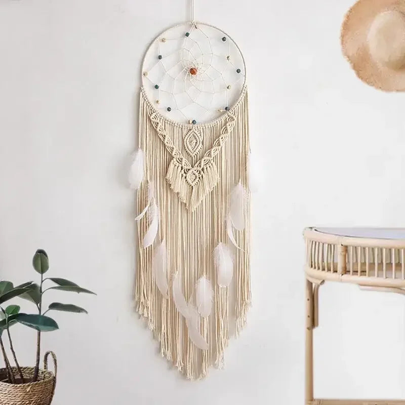attrape rêve macramé - attrape-rêve en macramé écru, plumes blanches et perles, accroché au mur blanc