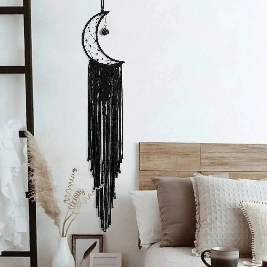 attrape rêve noir - croissant de lune noir accroché au-dessus d'une tête de lit