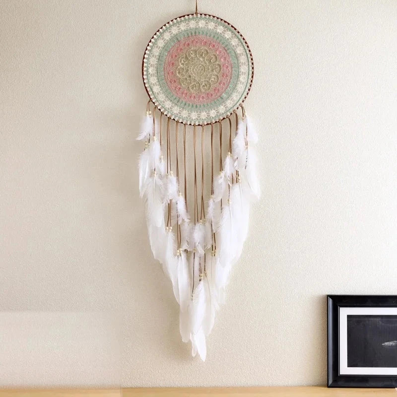 attrape rêve blanc - disque ajouré pastel et plumes blanches accroché à un mur crème