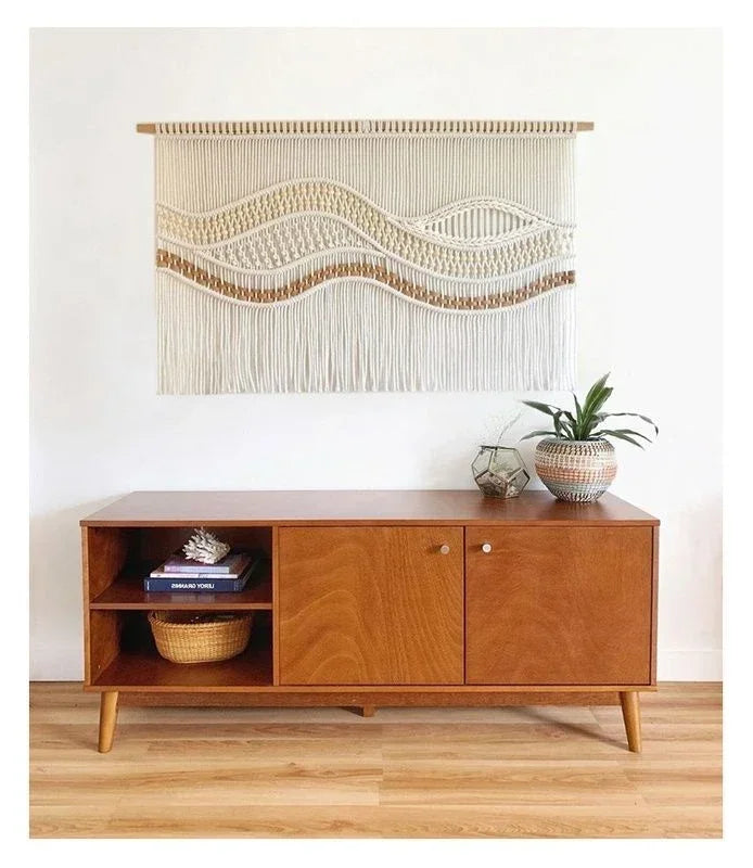 Décoration murale bohème macramé vagues — au-dessus d'un buffet bois vintage, accent caramel