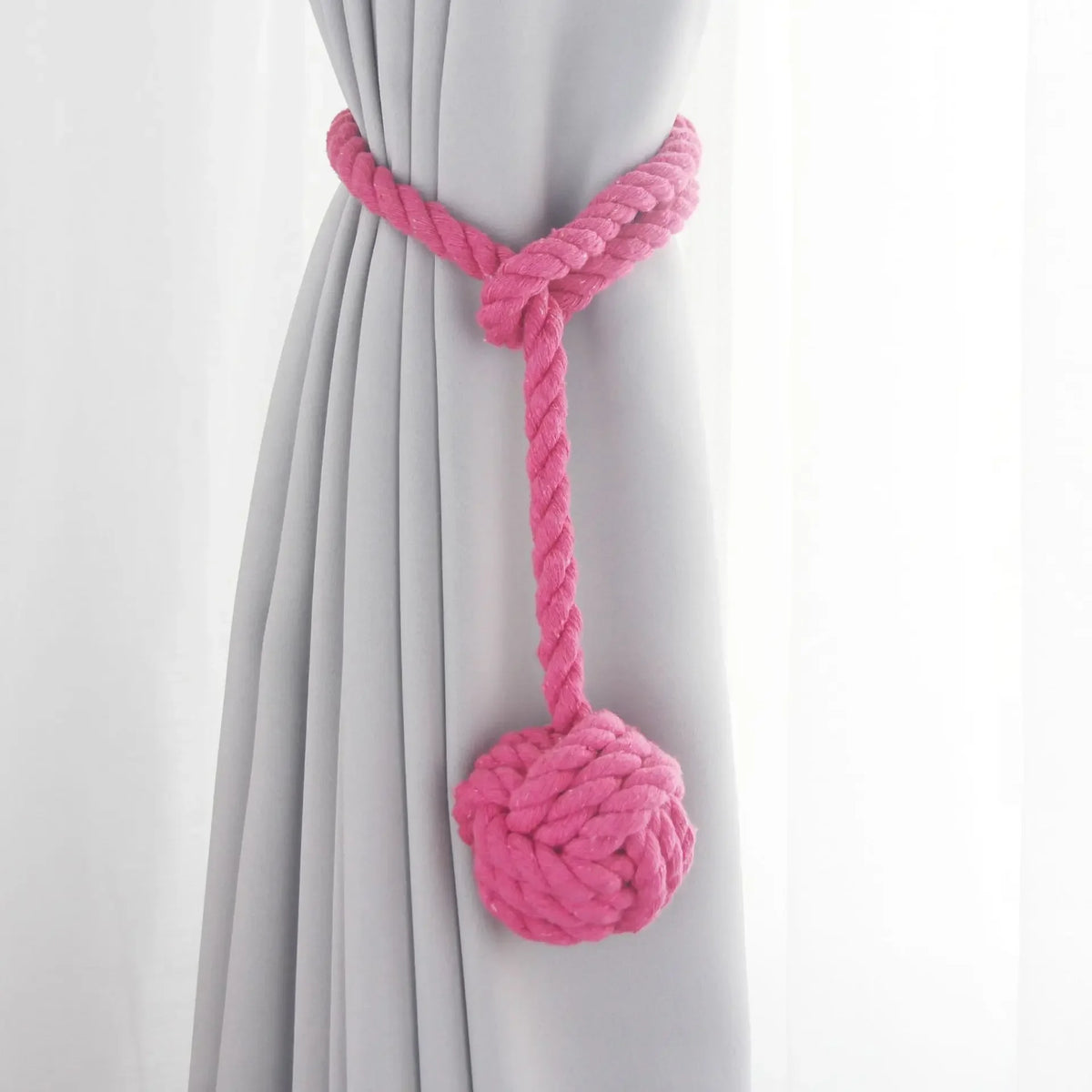 Embrasse rideau boule en corde de coton - coloris rose fuchsia, boule de coton nouée sur un rideau gris