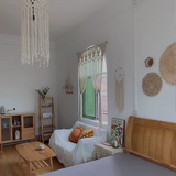 Rideau macramé papillon Orven devant fenêtre chambre, décoration attrape-rêves et canapé blanc