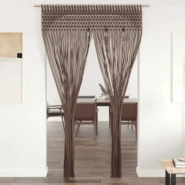 Rideau macramé taupe - dans une embrasure de porte, cordons regroupés en deux pans devant une salle à manger