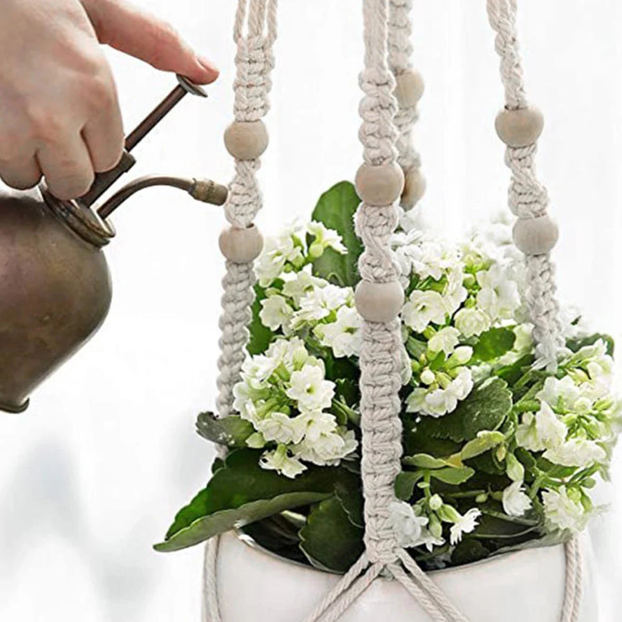 Support pot de fleurs suspendu macramé - gros plan sur les perles en bois et des fleurs blanches