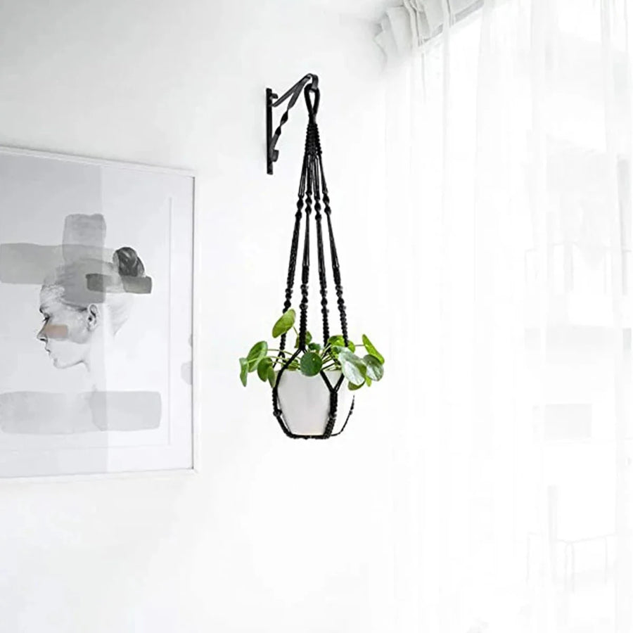 Support pot de fleurs suspendu macramé - coloris noir accroché à une équerre noire sur un mur blanc