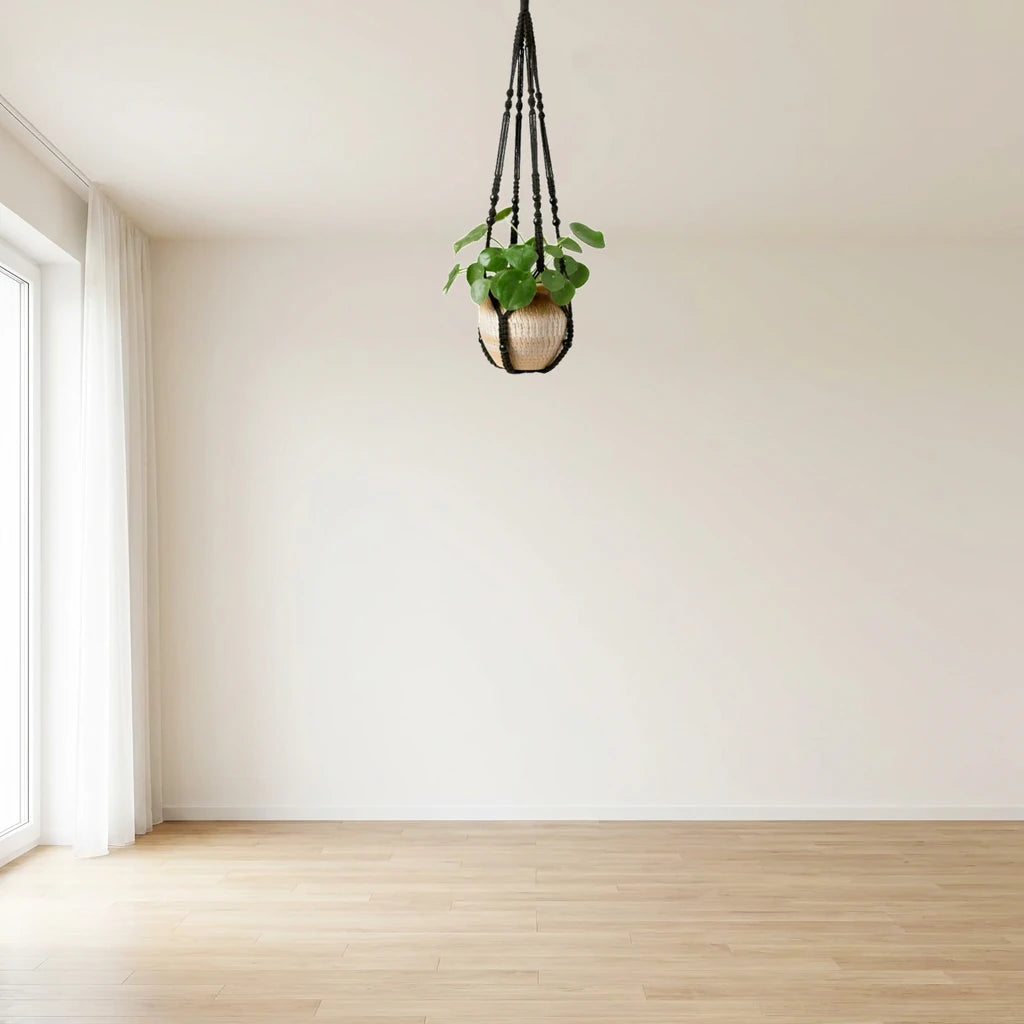 Support pot de fleurs suspendu en macramé noir avec perles, dans un salon clair