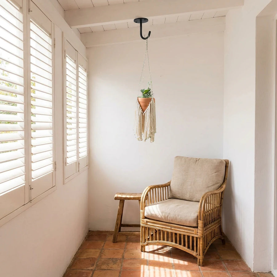 Suspension pour plantes macramé - modèle à franges dans une véranda avec fauteuil en rotin et carrelage terre cuite